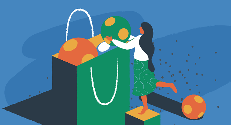 A woman fills a shopping bag with balls.