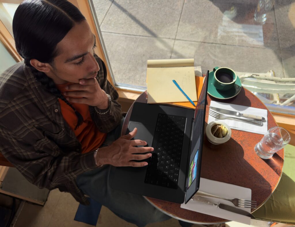 A designer sits and works on his Macbook Pro. 