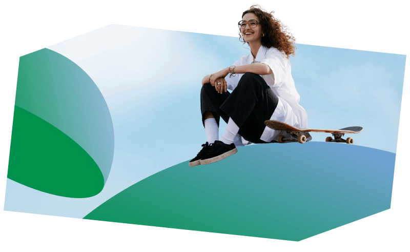 A woman with a skateboard sits on a large  blue and green sphere. 